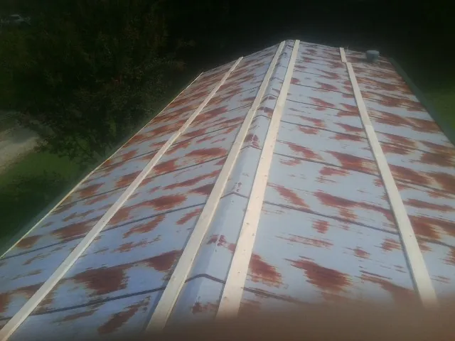 Rusted metal roof panels with new wood purlins before replacement — Storm Damage Roof Repair in Hay Springs by Roofing Brothers