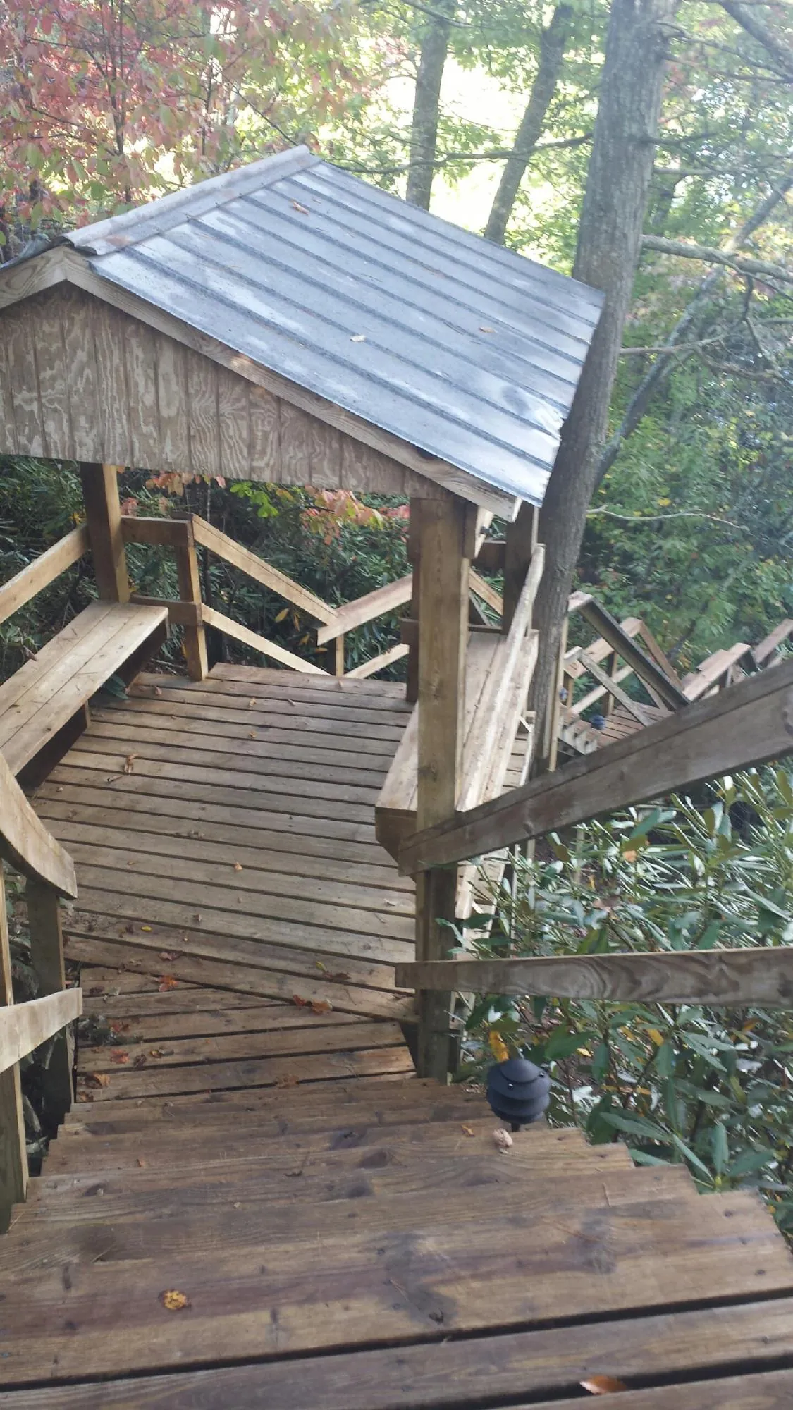 Metal roofed shelter over wooden steps on a wooded walkway — Skylight Repair & Installation work by our crew in Hay Springs