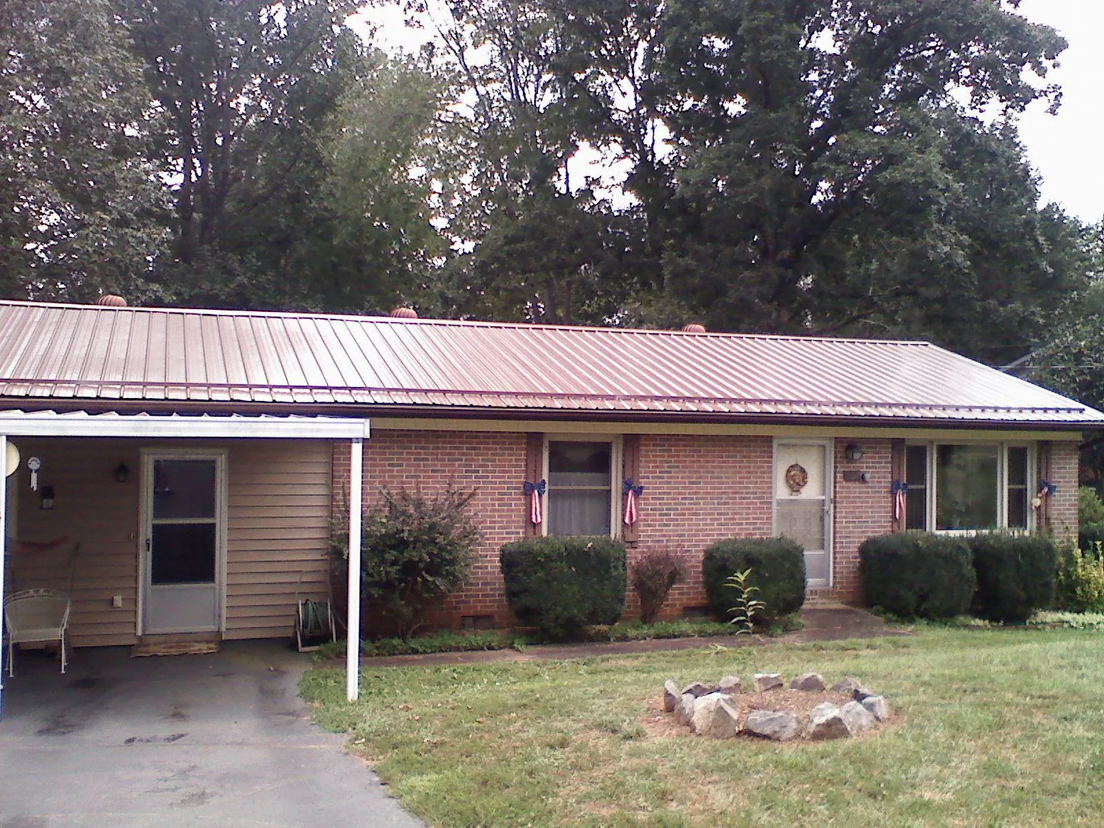 Bronze metal roof and carport on a brick ranch home — Roof Repair work by our crew in Hay Springs